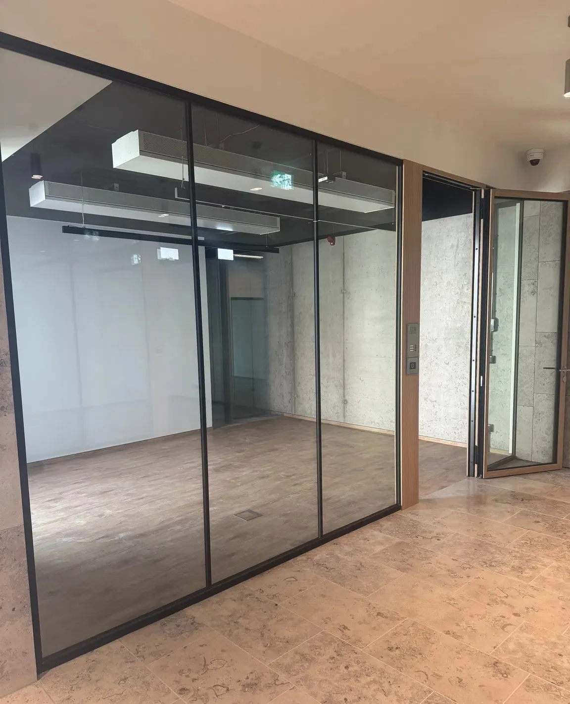 Sala konferencyjna za szklaną ścianą w czarnych ramach